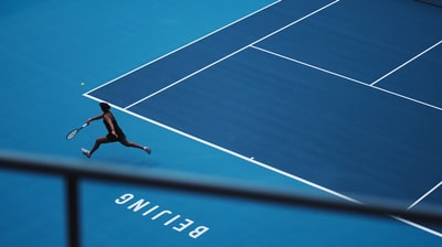 在球场上打网球的人